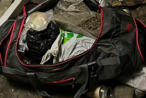 Na zdjęciu torba turystyczna wypełniona workami z suszem marihuany.