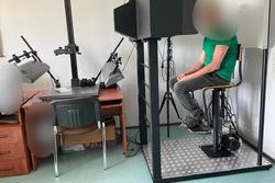 mężczyzna siedzący na krześle podczas wykonywania zdjęć przez technika kryminalistyki